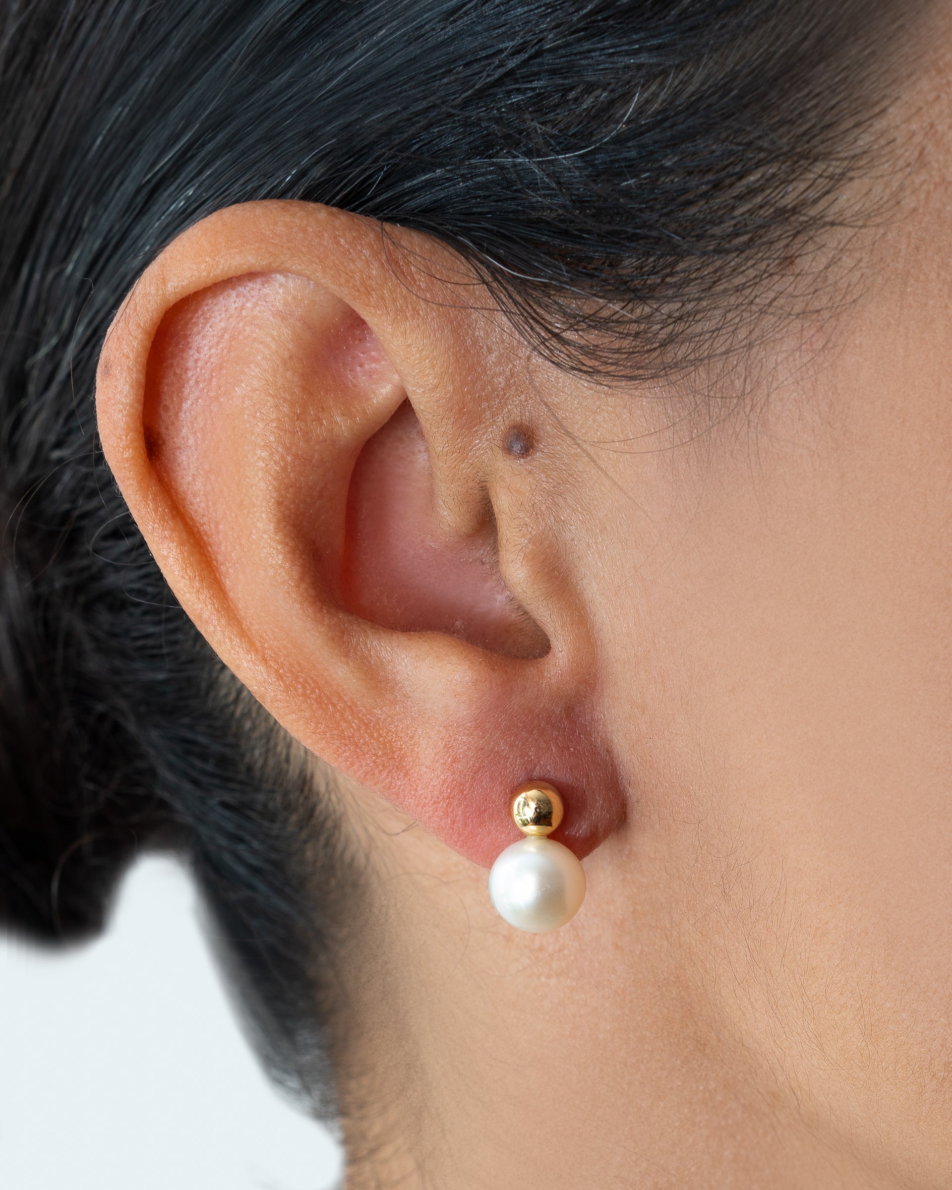 Par de brincos com base esférica de ouro e pérola pendente, uma peça de design exclusivo Rose Mafra.